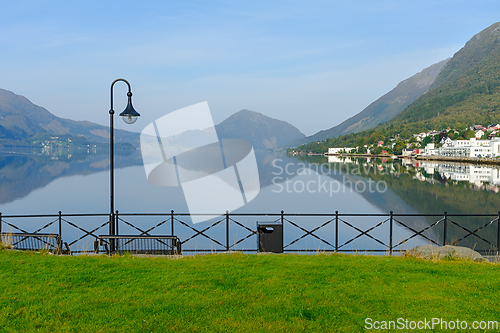 Image of A serene seaside view featuring a reflective surface, mountains 