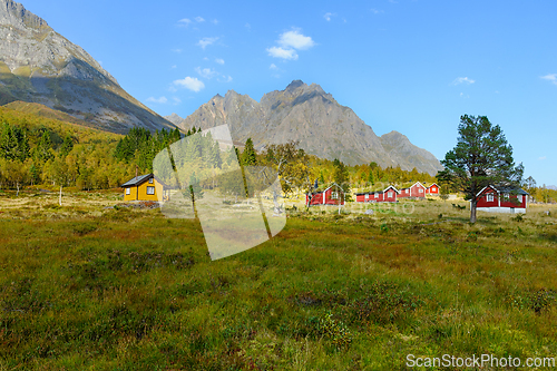 Image of Autumn landscape with yellow and red cabins nestled among mounta