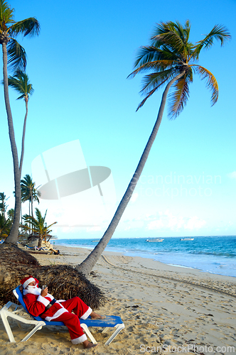 Image of Santa Claus is on vacation on a tropical beach. 