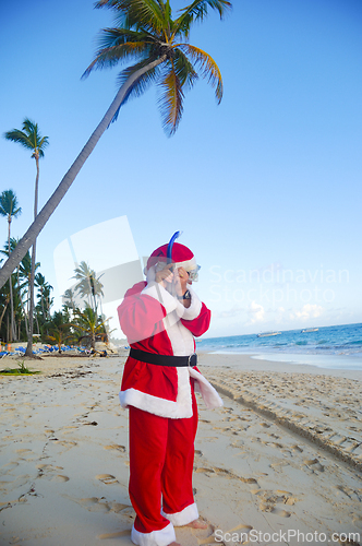 Image of Santa Claus is on vacation on a tropical beach. 