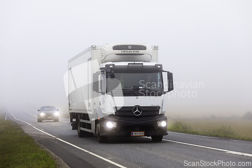 Image of White Mercedes Benz Antos Truck Transports Goods in Morning Fog