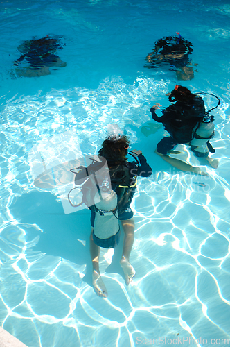Image of Divers are diving in a pool