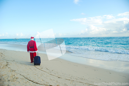 Image of Santa Claus is on vacation on a tropical beach. 