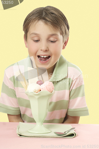 Image of Child looking at an ice cream sundae on a table.