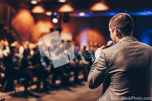 Image of Public speaker giving talk at Business Event.