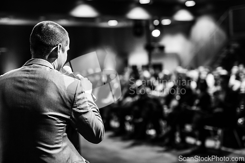 Image of Public speaker giving talk at Business Event.