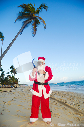Image of Santa Claus is on vacation on a tropical beach. 