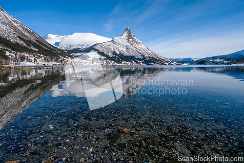 Image of Clear waters reflect snow-capped peaks in a serene mountain land