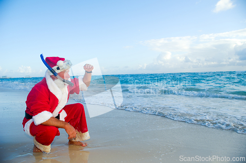 Image of Santa Claus is on vacation on a tropical beach. 