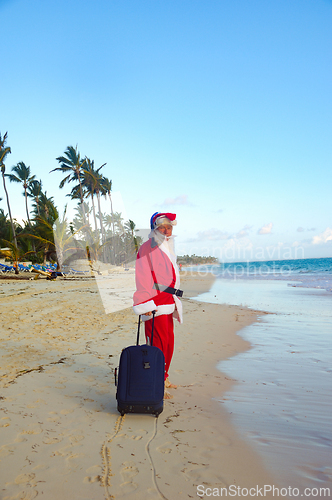 Image of Santa Claus is on vacation on a tropical beach. 