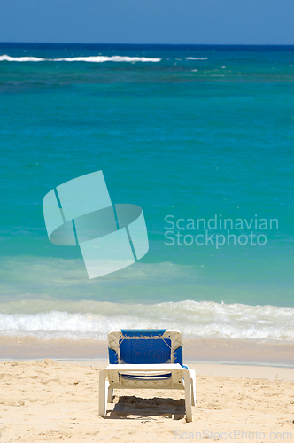Image of A sun lounger and palm at exotic beach with white sand