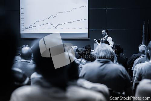 Image of Speaker Giving a Talk at Business Meeting. Audience in the conference hall. Business and Entrepreneurship concept. Black and white blue toned image