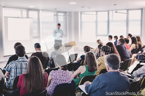 Image of Speaker giving presentation talk at business conference.