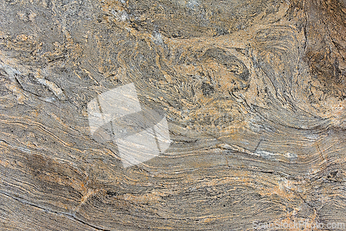 Image of Textured rock formation displaying swirling patterns of earth to