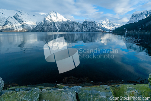 Image of Stunning winter landscape of snow-covered mountains reflecting i