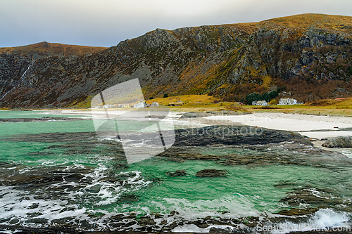 Image of Scenic view of a coastal landscape with green waters and rocky s