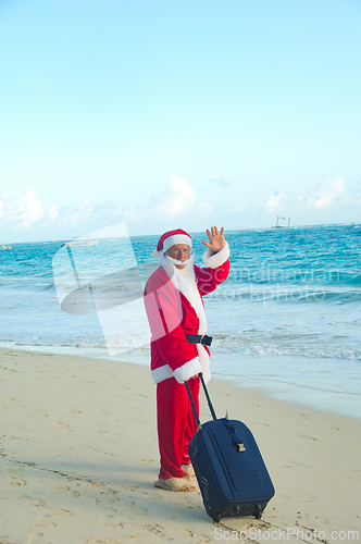 Image of Santa Claus is on vacation on a tropical beach. 