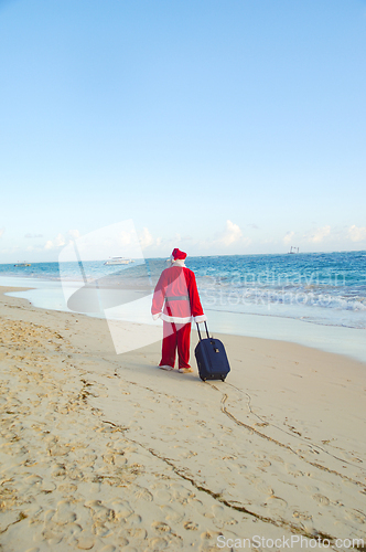 Image of Santa Claus is on vacation on a tropical beach.