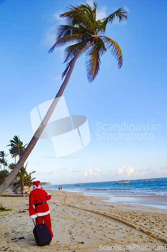 Image of Santa Claus is on vacation on a tropical beach.