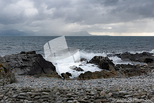 Image of A dramatic coastal view featuring crashing waves against rocky s