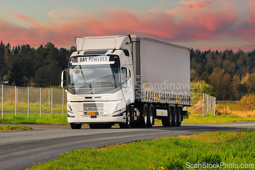 Image of Driving Gas Powered Volvo FM Truck Semi Trailer in Morning Light