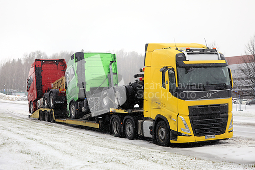 Image of Yellow Volvo FH Vehicle Carrier Hauls New Trucks