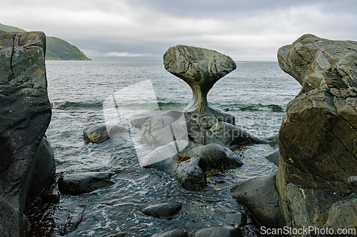 Image of Unusual rock formation on the shoreline near a tranquil sea unde