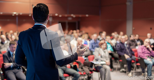 Image of Public speaker giving talk at business event.