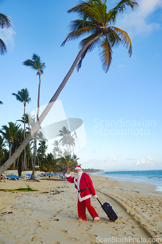 Image of Santa Claus is on vacation on a tropical beach. 