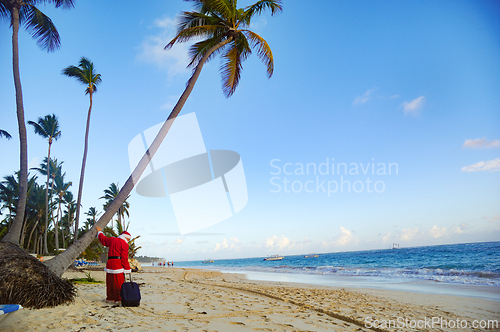 Image of Santa Claus is on vacation on a tropical beach.