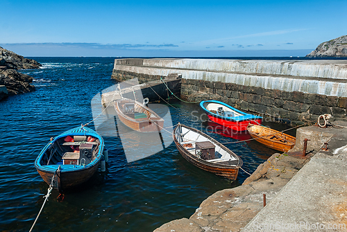 Image of Several small boats are docked in a harbor on a sunny day
