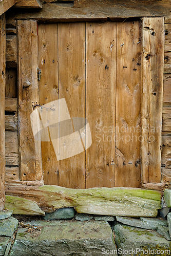 Image of A weathered wooden door on a rustic cabin in the countryside