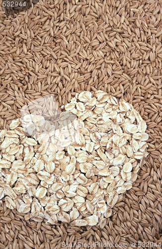 Image of Oats seeds and oat-flakes heart - background