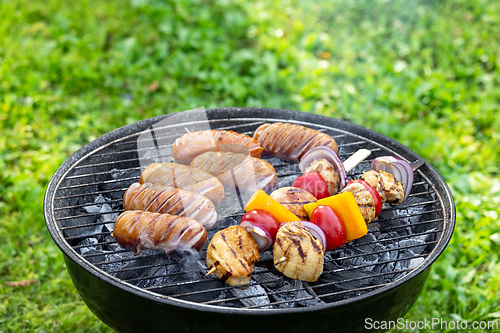 Image of grilled sausages and meat vegetables skewers