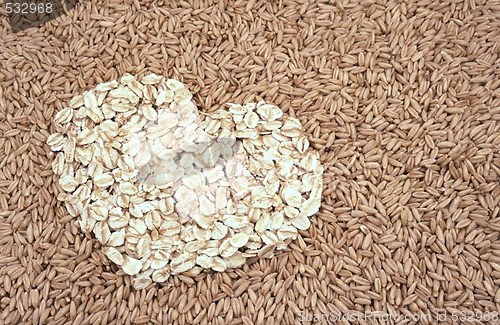 Image of Oats seeds and oat-flakes heart - background