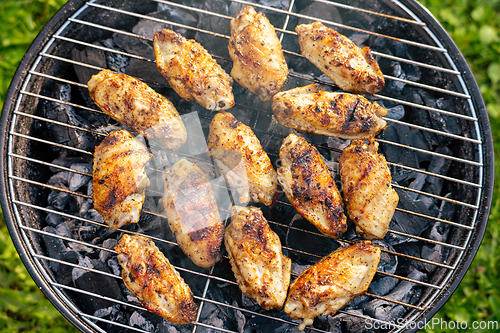 Image of chicken wings grilling on charcoal grill
