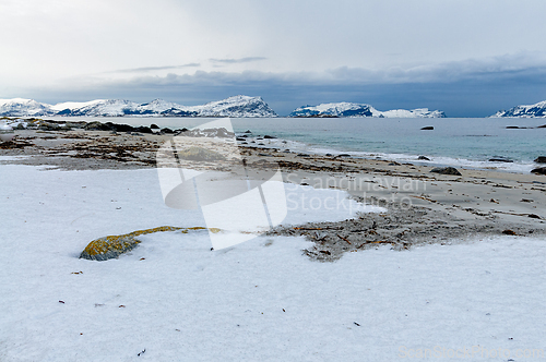 Image of A snow-covered beach with a view of snow-capped mountains in the