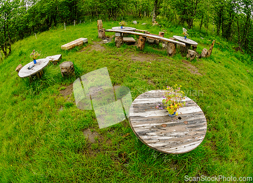 Image of A charming wooden seating area surrounded by lush greenery, perf
