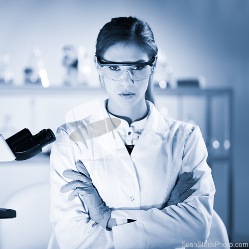 Image of Portrait of a attractive, young, confident female health care professional in hes working environment. Blue toned black and white image