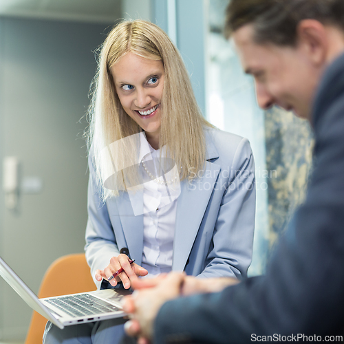 Image of Business meeting. Client consulting. Confident business woman, real estate agent, financial advisor explaining details of project or financial product to client in office.