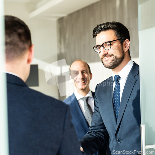 Image of Group of confident business people greeting with a handshake at business meeting in modern office or closing the deal agreement by shaking hands.