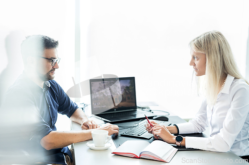 Image of Business meeting. Client consulting. Confident business woman, real estate agent, financial advisor explaining details of project or financial product to client in office.
