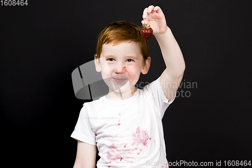 Image of red-haired boy eating strawberries