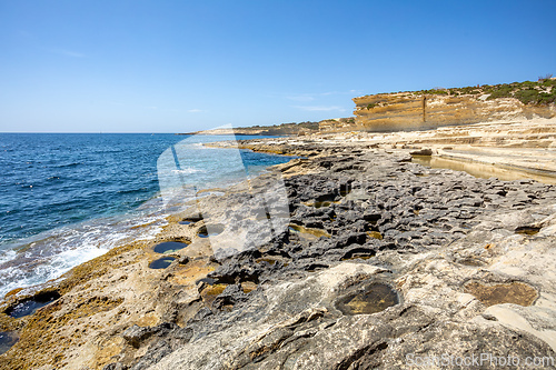 Image of Crystal clear turquoise water in blue lagoon. St. Peters pool - rocky beach at Malta