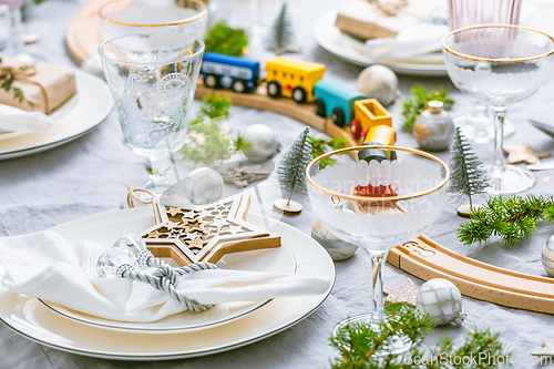 Image of Traditional festive place setting for Christmas, decorated with wooden railways