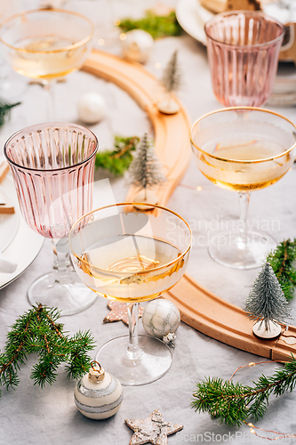 Image of Traditional festive place setting for Christmas, glasses of sparkling wine