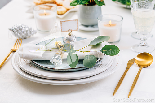 Image of Traditional festive place setting for Christmas, decorated with eucalyptus branch