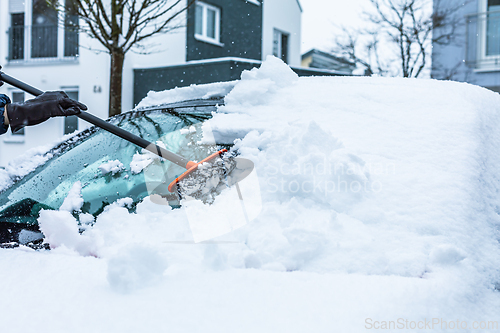 Image of Cleaning and scraping windscreen from snow