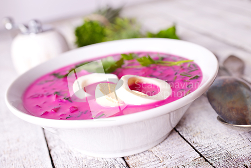 Image of Cold beetroot soup in bowl on wooden background