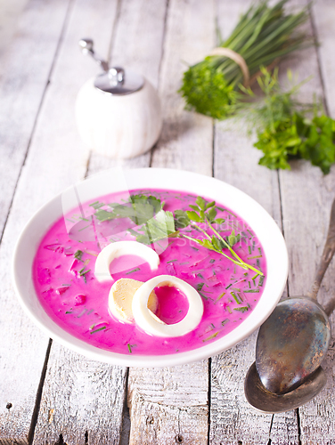 Image of Cold beetroot soup in bowl on wooden background